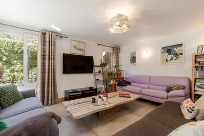 a living room with a purple couch and a table at Chalet du Verney - Pied du Prarion - Sauna in Les Houches