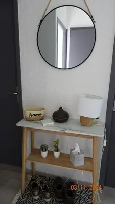 a mirror on a wall above a table with plants at La Comtesse in Saint-Gervais-les-Bains