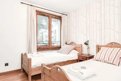 two beds in a room with a window at Apartment Balmat - Chamonix All Year in Chamonix-Mont-Blanc