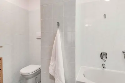 a white bathroom with a toilet and a sink at Apartment Balmat - Chamonix All Year in Chamonix-Mont-Blanc