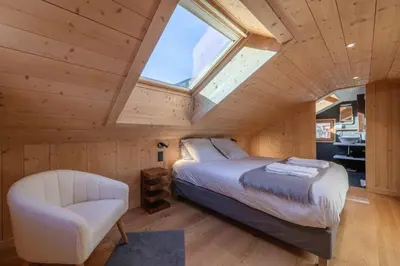 a bedroom with a bed and a chair at Chalet Altiora in Chamonix-Mont-Blanc