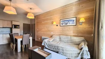 a bedroom with a wooden wall with a bed and a table at Résidence Le Panoramic - Appartement spacieux · Départ et retour skis aux pieds · Piscine · Parking inclus · Spa MAE-3063 in Magland