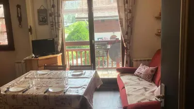 a room with a table and a couch and a window at Résidence Telepherique - TELEPHERIQUE 8 MAE-2363 in Saint-Gervais-les-Bains