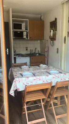 a kitchen with a table and chairs with a table at Résidence Telepherique - TELEPHERIQUE 8 MAE-2363 in Saint-Gervais-les-Bains