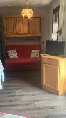 a bedroom with a red bed and a television at Résidence Telepherique - TELEPHERIQUE 8 MAE-2363 in Saint-Gervais-les-Bains