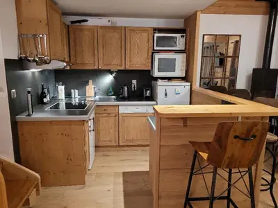 a kitchen with wooden cabinets and a counter top at Duplex vue sur montagne in Saint-Gervais-les-Bains