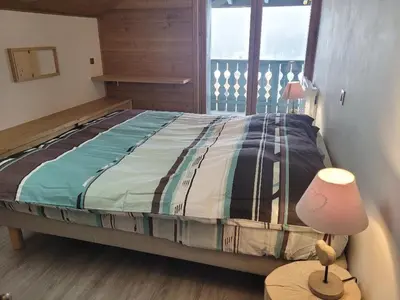 a bedroom with a bed and a lamp on a table at Duplex vue sur montagne in Saint-Gervais-les-Bains