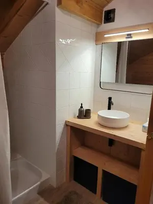 a bathroom with a sink and a mirror and a tub at Duplex vue sur montagne in Saint-Gervais-les-Bains