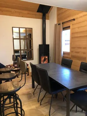 a dining room with a table and a fireplace at Duplex vue sur montagne in Saint-Gervais-les-Bains