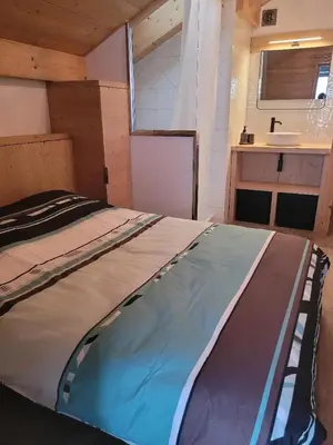 a large bed in a room with a sink at Duplex vue sur montagne in Saint-Gervais-les-Bains