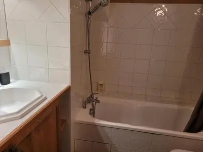 a bathroom with a bath tub and a sink at Duplex vue sur montagne in Saint-Gervais-les-Bains