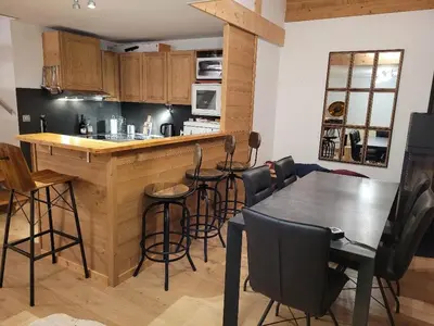 a kitchen with a bar and a table and chairs at Duplex vue sur montagne in Saint-Gervais-les-Bains