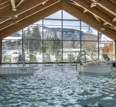a large pool of water in a building with windows at Cozy apartment in Arâches-la-Frasse