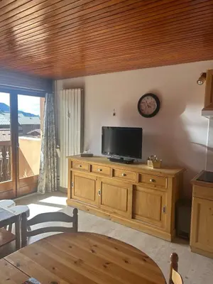 a living room with a television on a wooden dresser at Cozy apartment in Arâches-la-Frasse