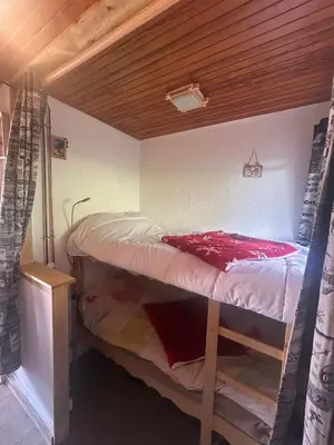a bunk bed in a room with a wooden ceiling at Cozy apartment in Arâches-la-Frasse