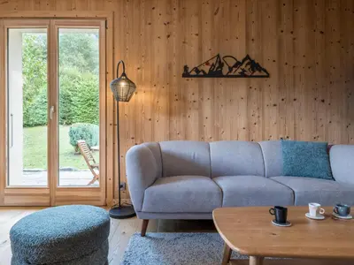 a living room with a couch and a table at Chalet Tannuaz - 4 Bedrooms - Quiet area - By Cozee Rentals in Les Houches