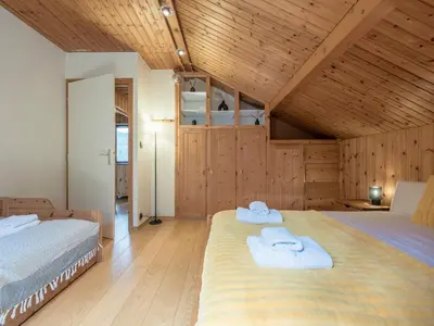 two beds in a room with wooden walls at Chalet Tannuaz - 4 Bedrooms - Quiet area - By Cozee Rentals in Les Houches