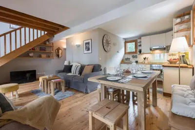 a living room with a table and a kitchen at Spacious duplex with terrace in Les Houches in Les Houches