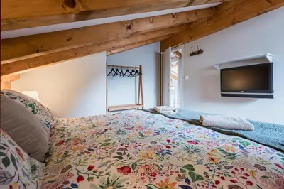 a bedroom with a bed and a tv on the wall at Spacious duplex with terrace in Les Houches in Les Houches