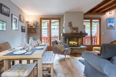 a living room with a table and a fireplace at Spacious duplex with terrace in Les Houches in Les Houches