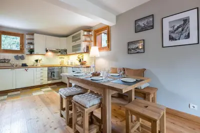 a large kitchen with a wooden table and chairs at Spacious duplex with terrace in Les Houches in Les Houches