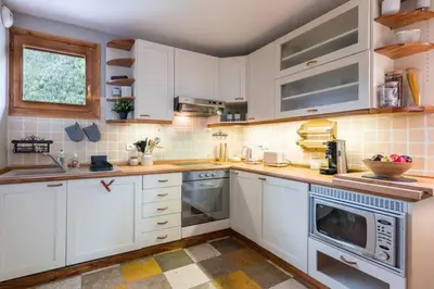 a white kitchen with white cabinets and appliances at Spacious duplex with terrace in Les Houches in Les Houches