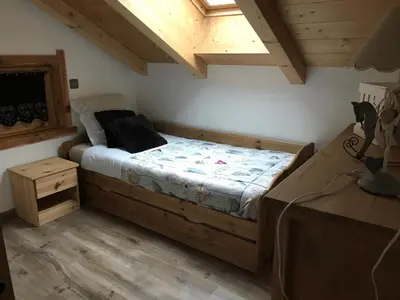 a bedroom with a bed in a room with wooden ceilings at Gite Le sommet in Sallanches