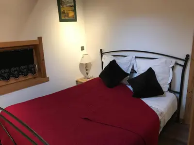 a bedroom with a red and white bed with black pillows at Gite Le sommet in Sallanches
