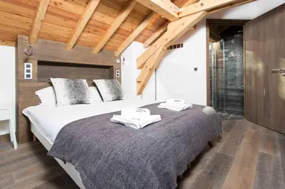 a bedroom with a large bed with towels on it at Chalet La Source - Chamonix All Year in Chamonix-Mont-Blanc
