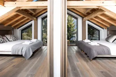 two beds in a room with large windows at Chalet La Source - Chamonix All Year in Chamonix-Mont-Blanc