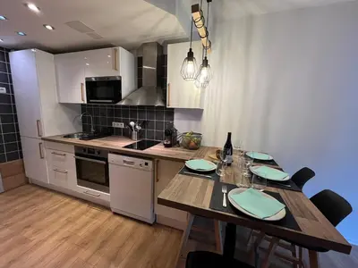 a kitchen with a wooden table with chairs and a dining room at Beautiful cozy and fully renovated apartment in Chamonix-Mont-Blanc