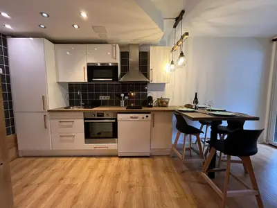 a kitchen with white appliances and a table with chairs at Beautiful cozy and fully renovated apartment in Chamonix-Mont-Blanc