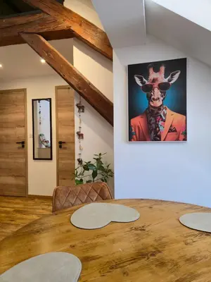 a living room with a wooden floor and a table at Appartement atypique au cœur de Sallanches in Sallanches