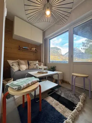 a living room with a couch and a table at Charming studio with balcony in Samoëns