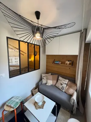 a living room with a couch and a table at Charming studio with balcony in Samoëns