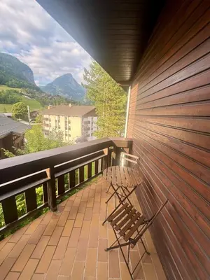 a bench on a balcony with a view of mountains at Charming studio with balcony in Samoëns