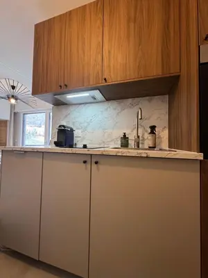 a kitchen with wooden cabinets and a counter top at Charming studio with balcony in Samoëns