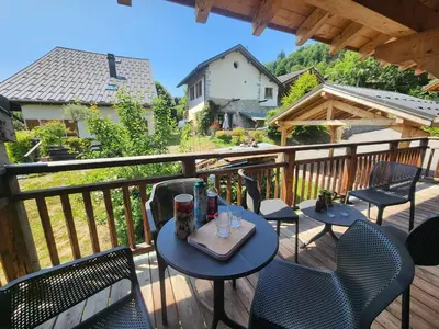 a patio with tables and chairs on a deck at Charmant T2 cabine exposé Ouest avec parking couvert - FR-1-629-148 in Samoëns