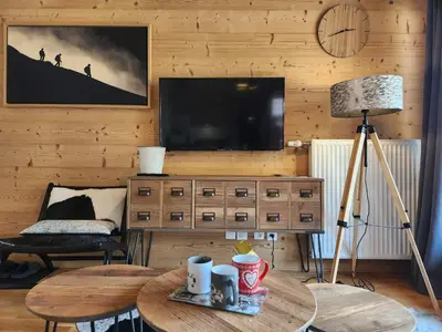 a living room with a television and a table with a lamp at Charmant T2 cabine exposé Ouest avec parking couvert - FR-1-629-148 in Samoëns