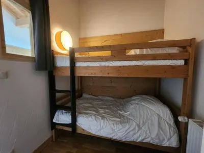 two bunk beds in a room with a window at Charmant T2 cabine exposé Ouest avec parking couvert - FR-1-629-148 in Samoëns