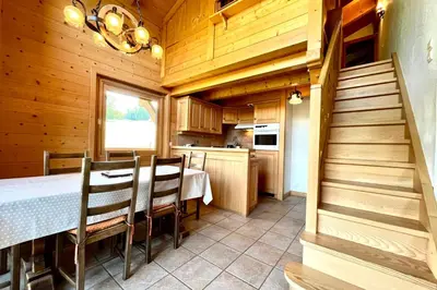 a kitchen and dining room with a table and chairs at Éclat Alpin in Combloux