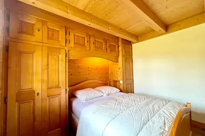 a bedroom with a bed in a wooden room at Éclat Alpin in Combloux