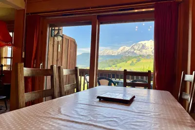a table in a room with a view of a mountain at Éclat Alpin in Combloux