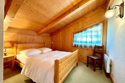 a bedroom with a bed in a wooden room at Éclat Alpin in Combloux