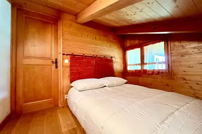 a bedroom with a bed in a wooden cabin at Éclat Alpin in Combloux