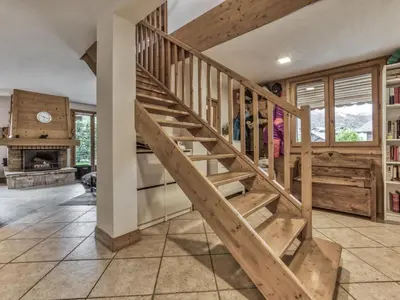 a wooden staircase in a house with a fireplace at Logan - Appartement spacieux 4 chambres - Animaux acceptés - Parking - FR-1-343-266 in Les Houches