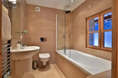 a bathroom with a sink and a toilet and a bath tub at Chalet Cristalliers - 5 Bedroom luxury chalet in central Chamonix with log fire and hot tub in Chamonix-Mont-Blanc