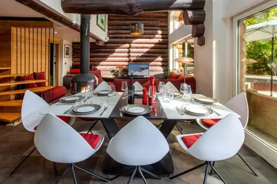 a dining room with a table and white chairs at Chalet des Cimes - Chamonix All Year in Chamonix-Mont-Blanc