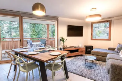 a living room with a wooden table and chairs at Appartement moderne - Les houches in Les Houches