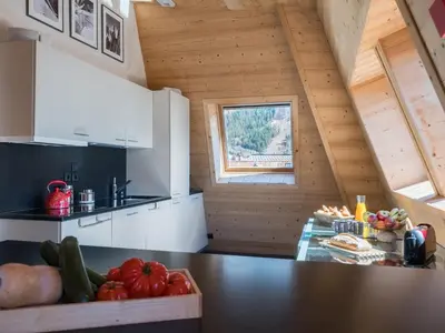 a kitchen with white cabinets and a black counter top at Penthouse Le Paradis I Le Chalet Club in Chamonix-Mont-Blanc